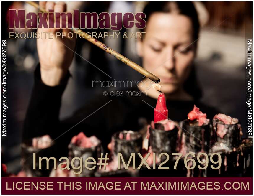 Woman lighting incense at Buddhist Temple