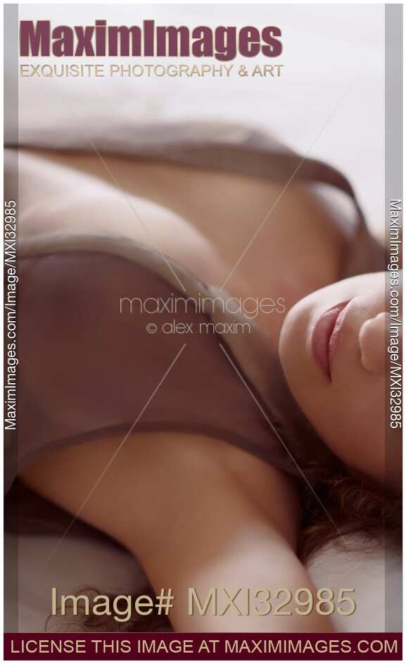 Woman lying in bed with her dress open on her chest Sensual closeup of lips in soft white light Making love artistic concept