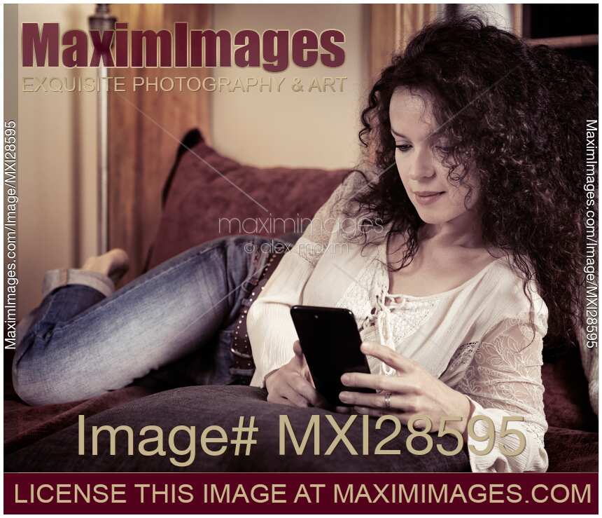 Woman lying on a sofa with iPhone 7 smartphone