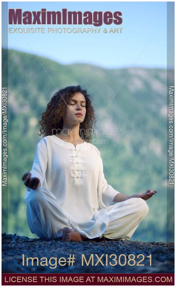Woman meditating in the morning sunrise in the nature