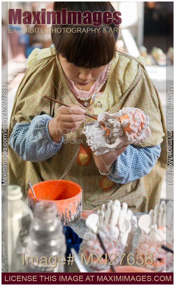 Woman painting a sculpture of a baby dragon