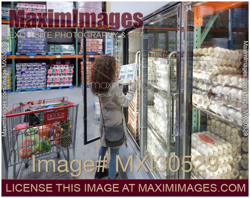 Woman picking a crate of eggs at Costco Wholesale warehouse store food section