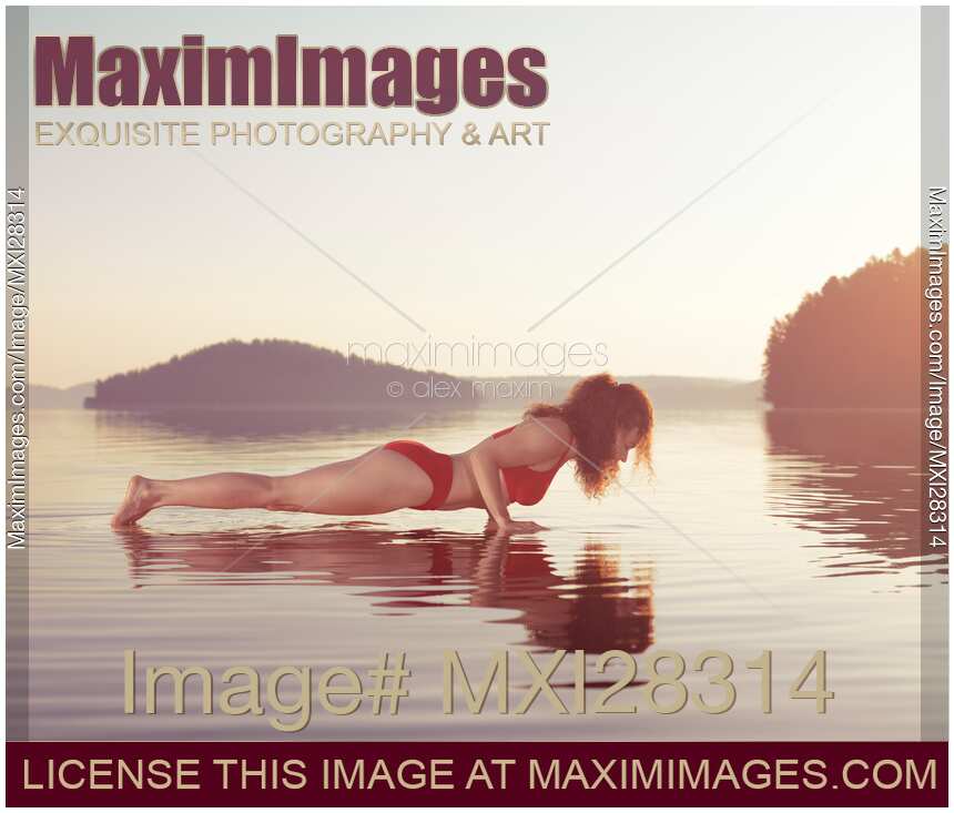 Woman practicing yoga on platform in the water Plank pose