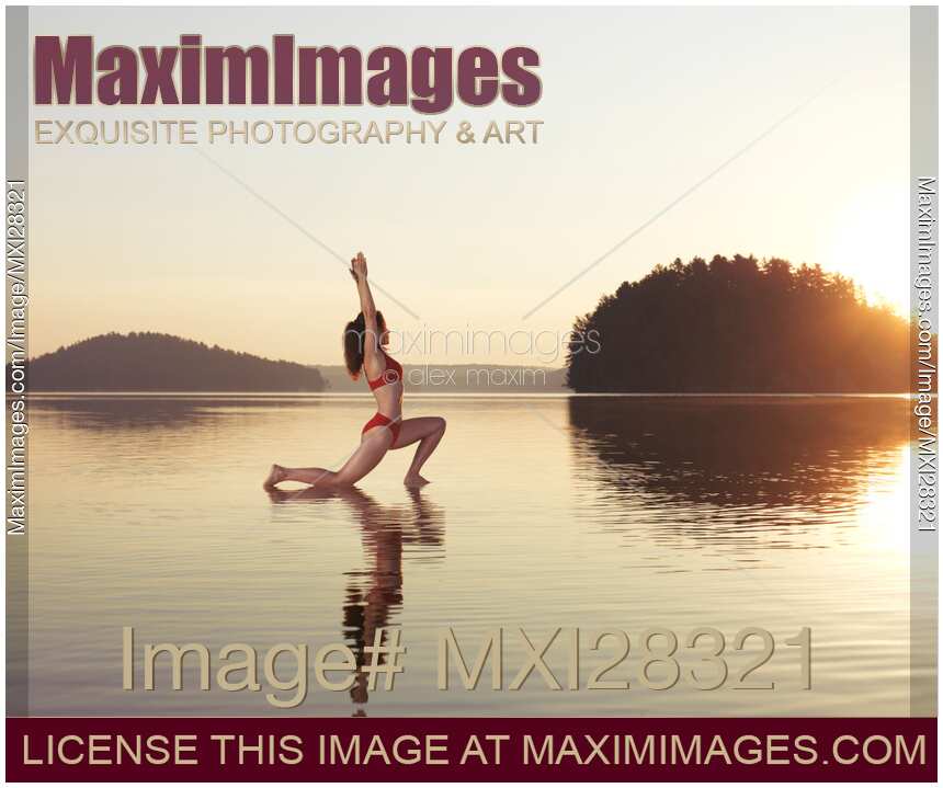 Woman practicing yoga on the water Anjaneyasana Low Lunge pose