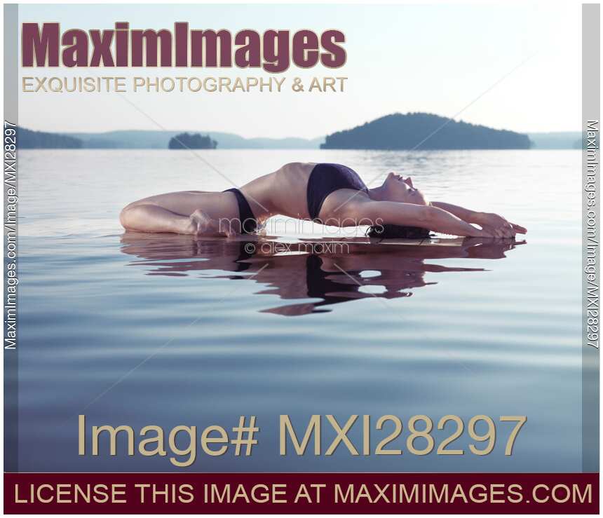 Woman practicing yoga on the water Fish pose Matsyasana