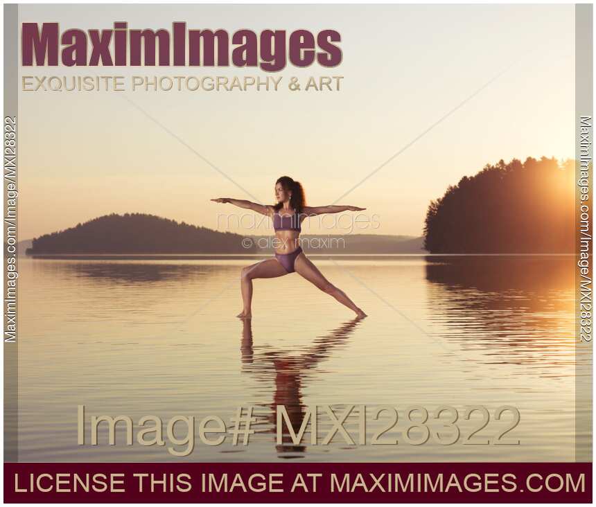 Woman practicing yoga on the water Veerabhadrasana warrior pose