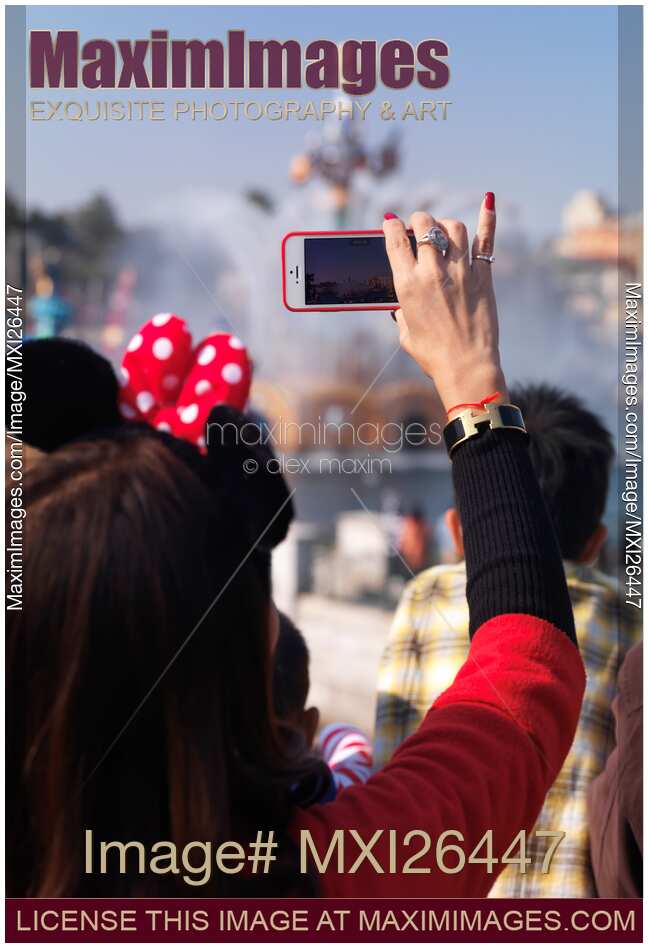 Woman recording a show with her iPhone at Tokyo Disneysea