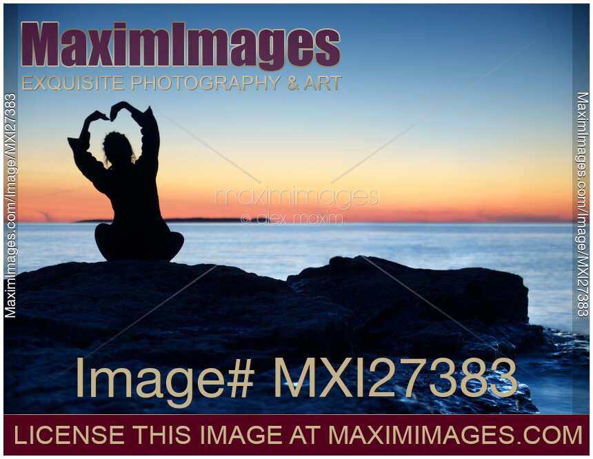 Woman silhouette alone on shore with hand in shape of flower