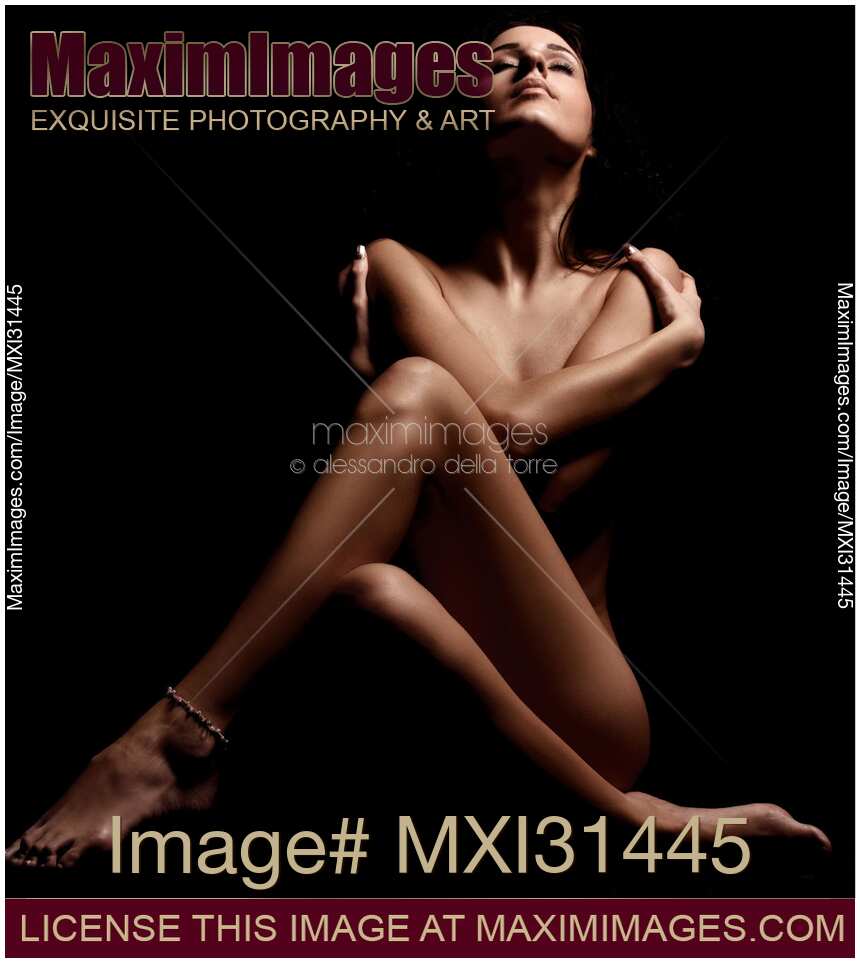 Woman sitting with her arms and legs crossed in front of her nude body