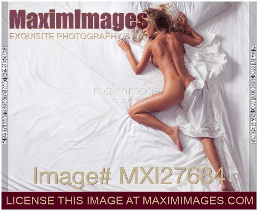 Woman sleeping naked in bed on white sheets View from above