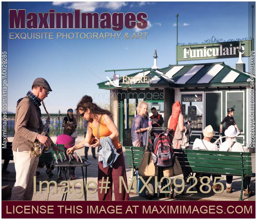 Woman tourist buying CD of street musician in Quebec city