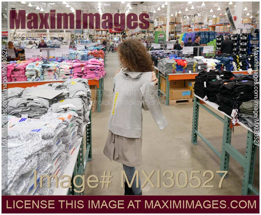 Photo of Woman trying on a sweater at Costco Wholesale warehouse store