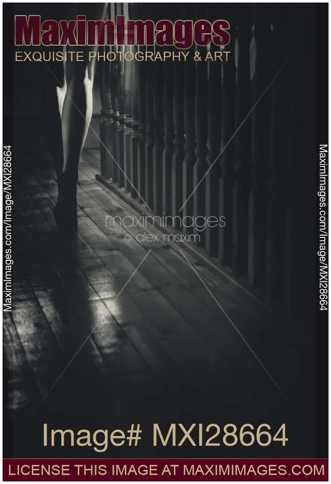 Woman walking barefoot in dark house Closeup of legs Black and white