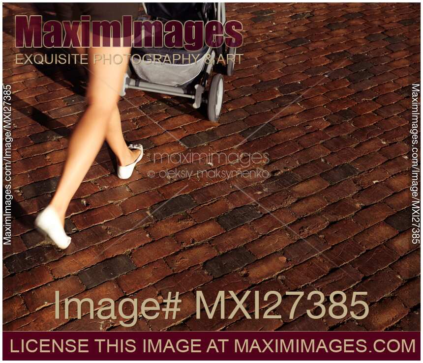 Woman walking with stroller on street