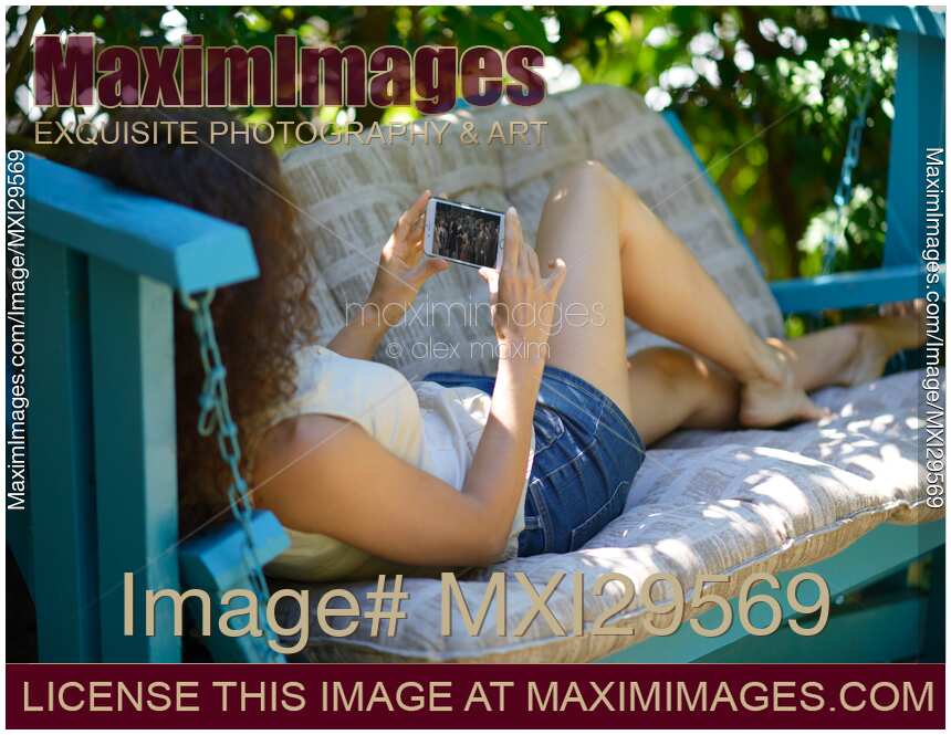 Woman watching video on iPhone smartphone screen outdoors