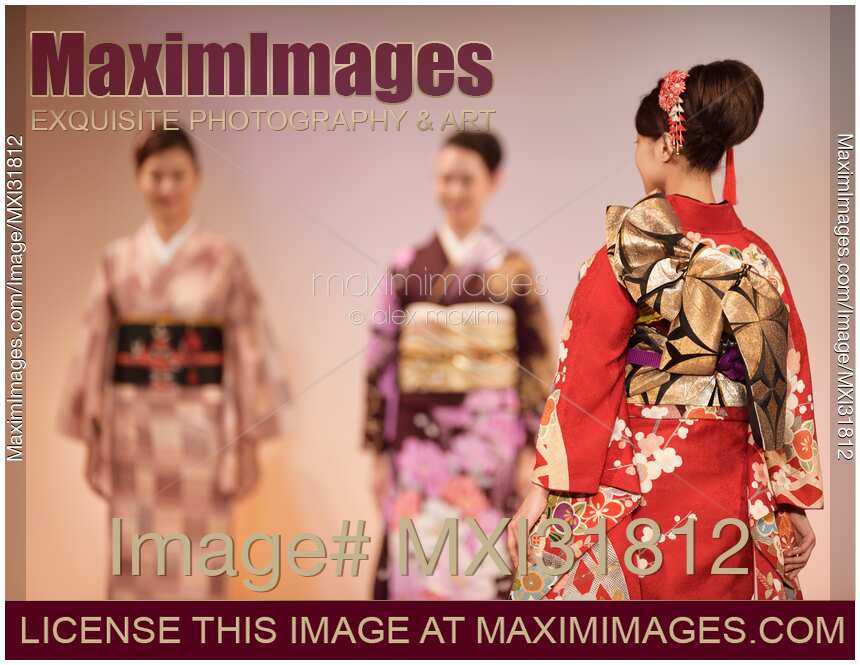 WOman wearing a kimono with obi belt in red and gold at Japanese fashion show