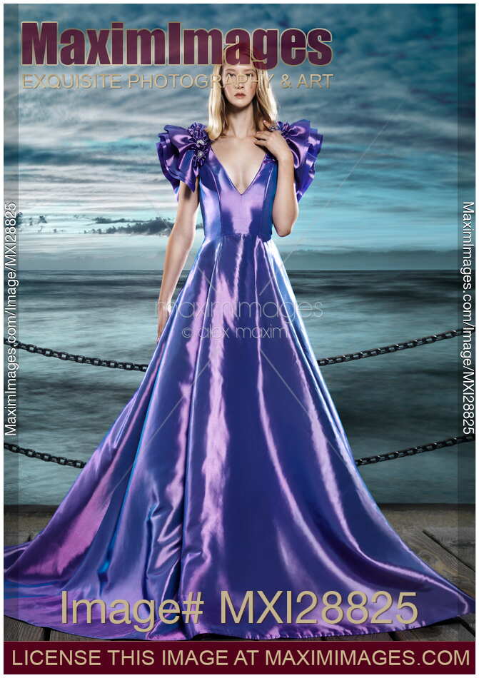 Woman wearing beautiful long blue dress at waterfront