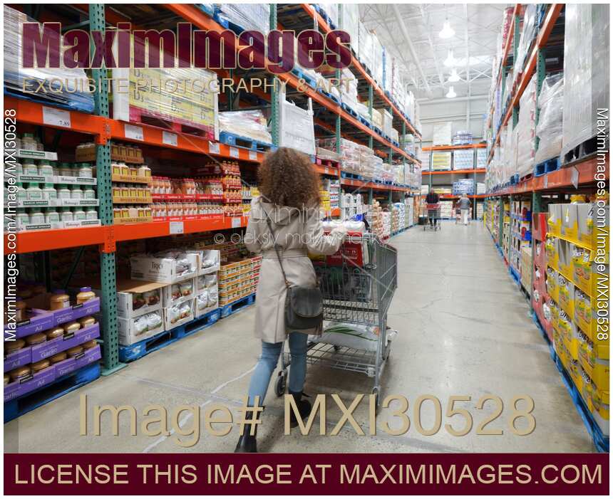 Woman with a cart walking at groceries section of Costco Wholesale warehouse store