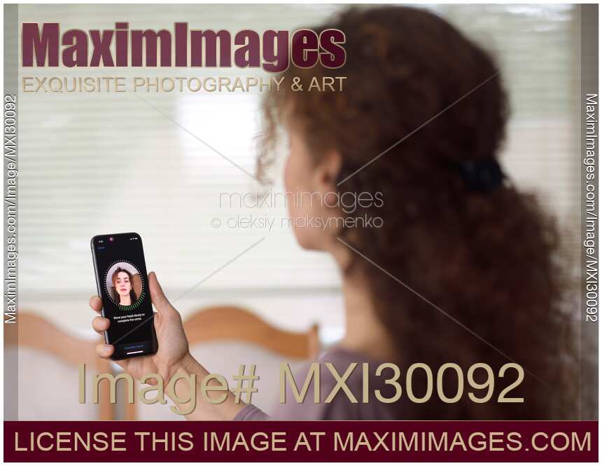 Woman with Apple iPhone X in her hand setting up Face ID