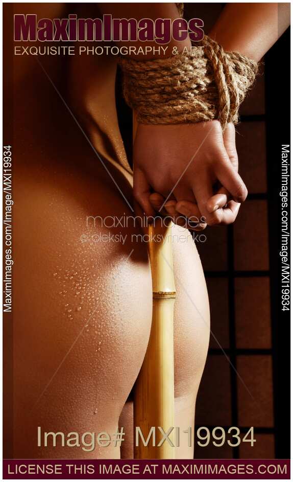 Woman with Her Hands Tied to Bamboo with shibari bondage ropes