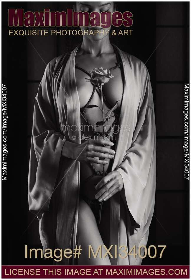 Woman with ropes of Shibari bondage tied around her sensual naked body holding a rose Art nude black and white