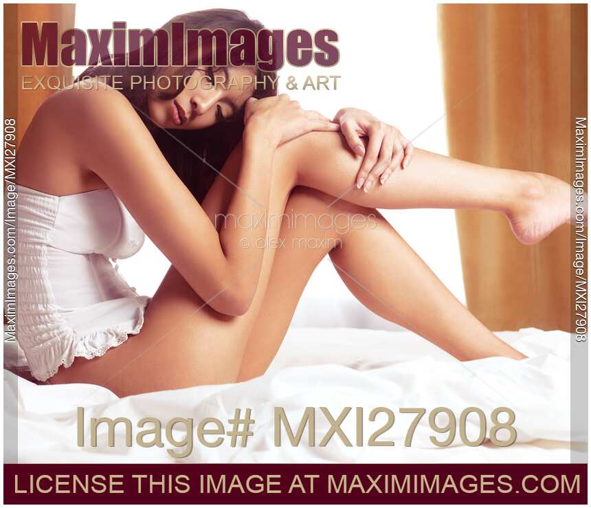 Young asian woman sitting in lingerie on a bed