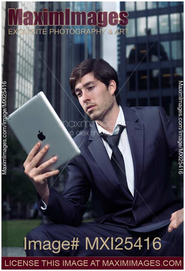 Young businessman with Apple iPad in a city