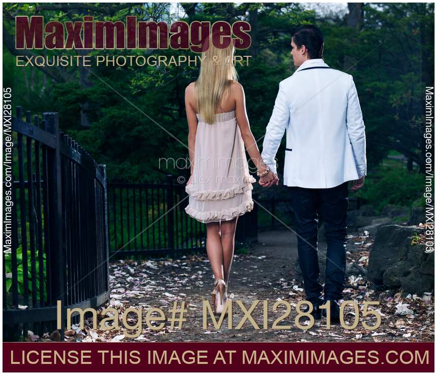 Young Couple Walking in a Park Holding Hands