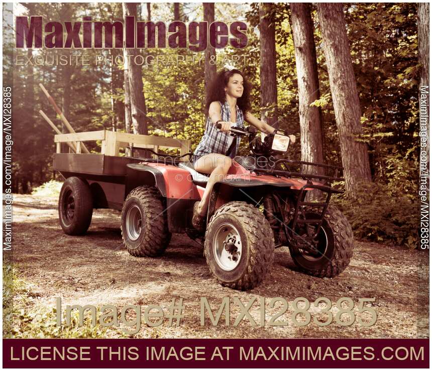 Young farm woman riding atv on country road