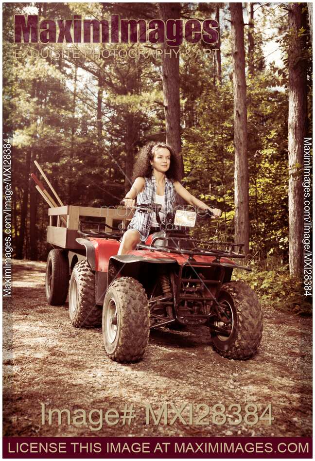 Young farm woman riding atv