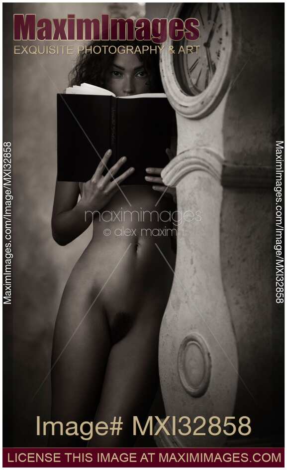 Young lady standing naked with a book leaning against an antique clock in old house Black and white art nude