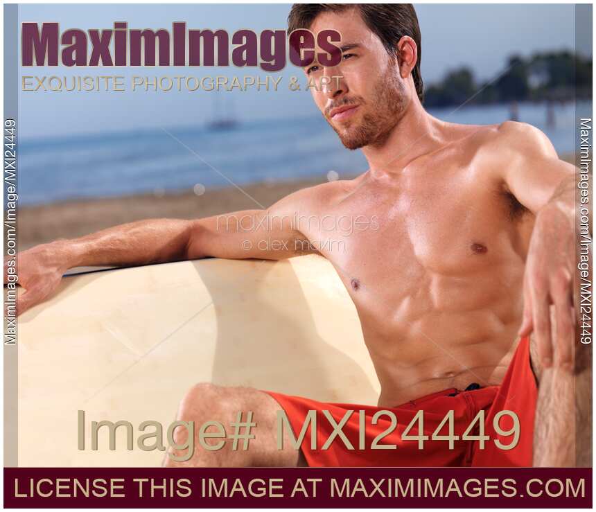 Young man at the beach with a surfboard