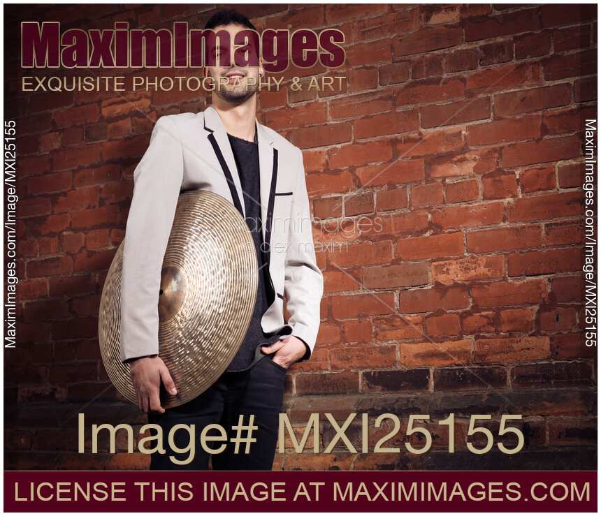 Young man drummer with a cymbal