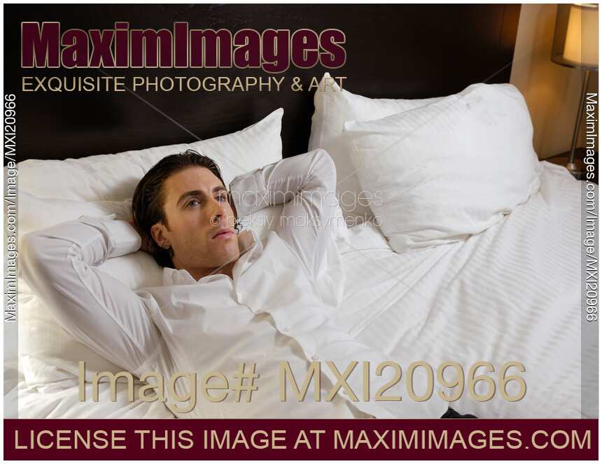 Young Man Lying Alone in Bed