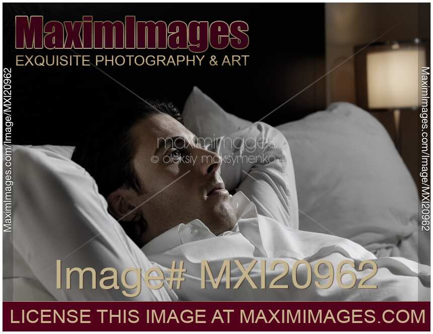 Young Man Lying in Bed Alone