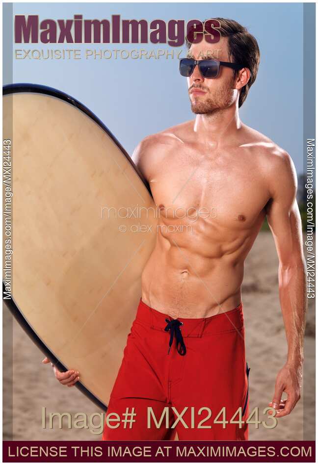 Young man with a surfboard at the beach