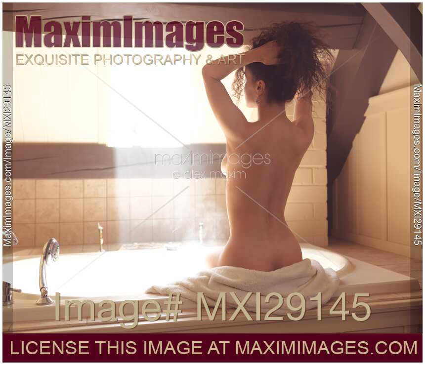 Young nude woman in a steamy brightly lit bathroom
