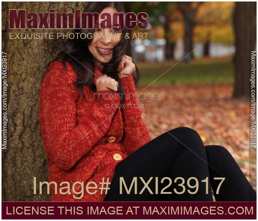 Young Smiling Woman Cuddling in a Sweater in the Wind