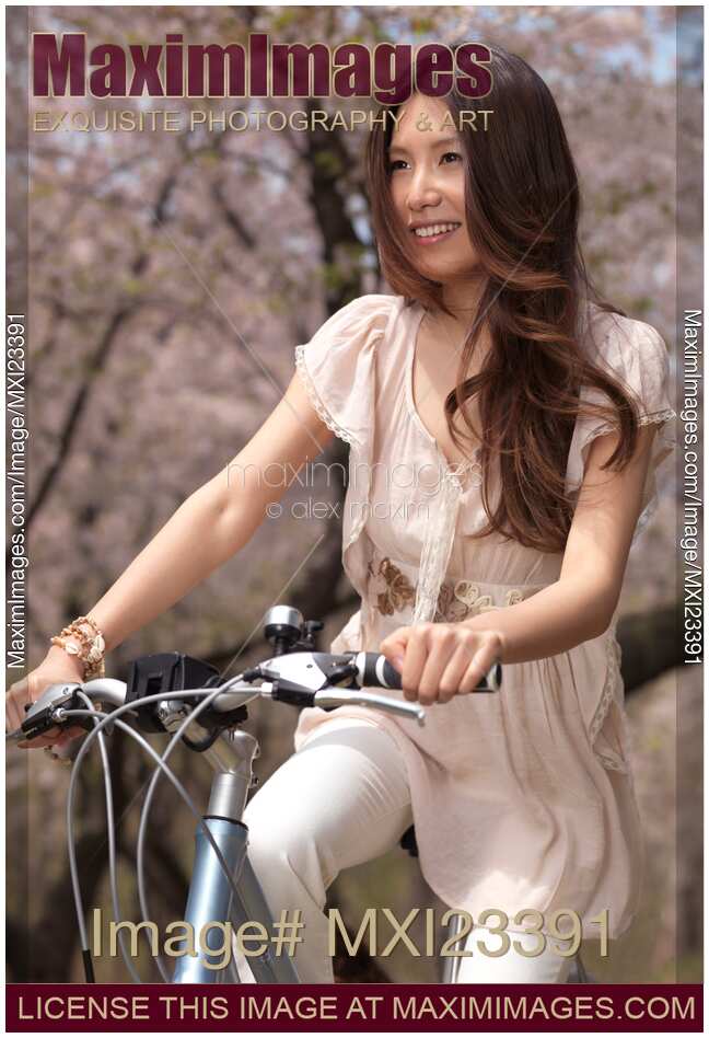 Young Smiling Woman Riding a Bike in a Park