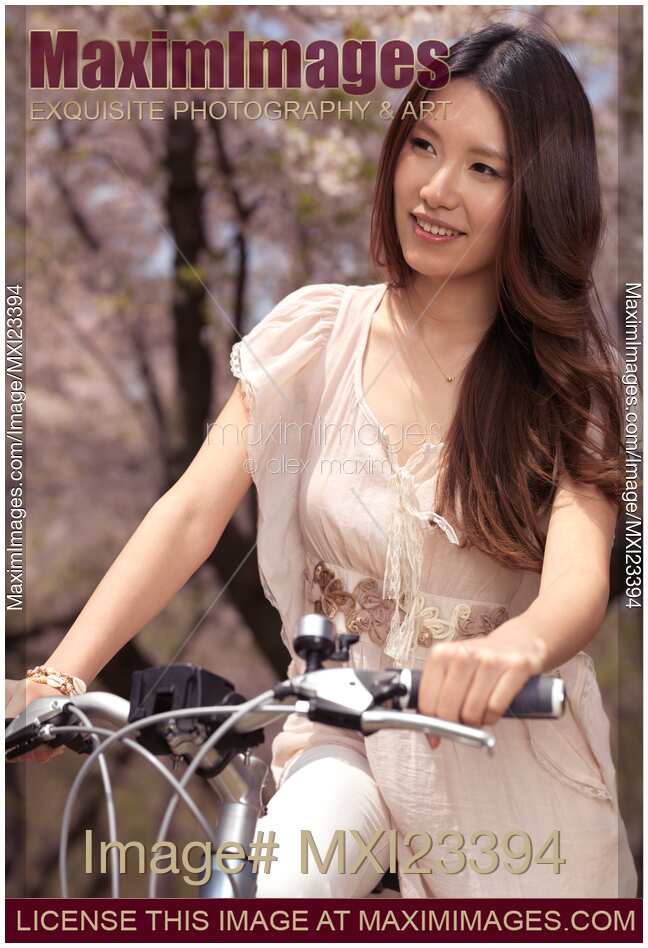Young Smiling Woman Riding a Bike in a Park