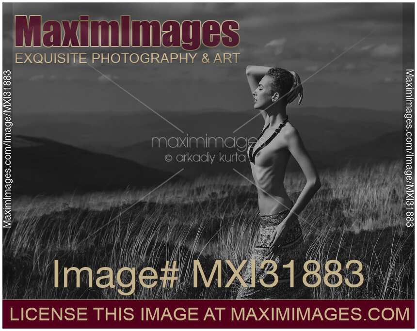 Young tribal woman standing topless in an open field
