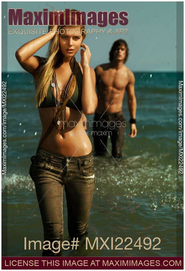 Young Woman and a Young Man Walking Out of Water