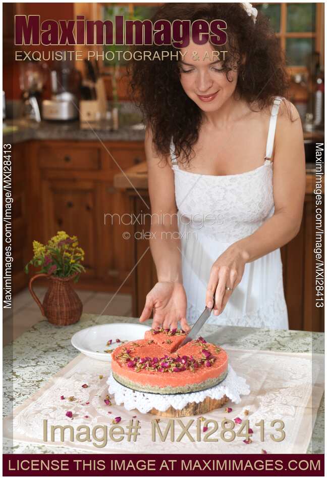 Young woman cutting off a slice of home-made cake