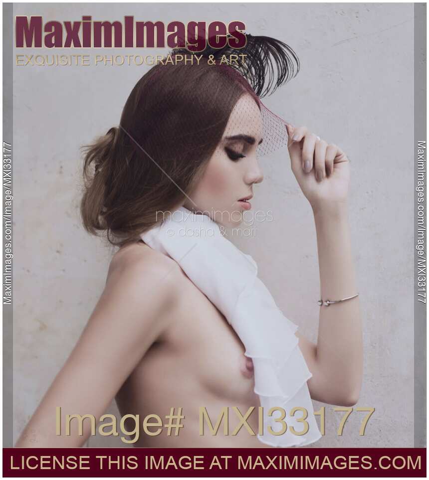 Young woman in a veil headpiece with a feathers and a white scarf barely covering her naked breast Sensual vintage portrait