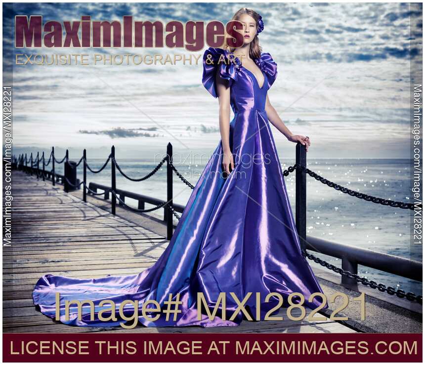 Young woman in beautiful long evening gown at waterfront