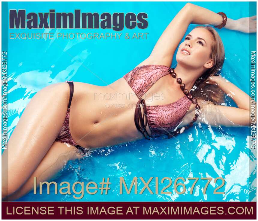 Young woman in bikini swimsuit lying in water