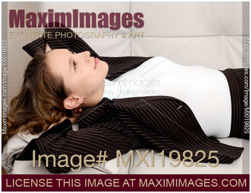 Young Woman in Business Suit Relaxing on Sofa