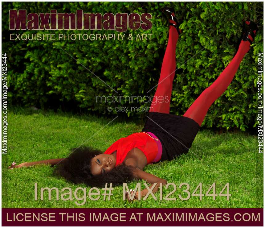 Young Woman in Fancy Bright Clothes Lying on the Grass
