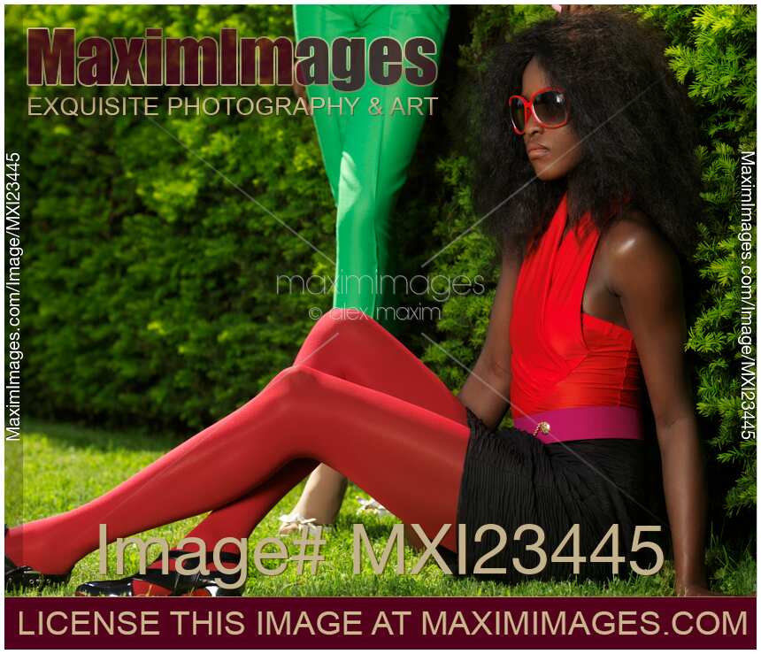 Young Woman in Fancy Bright Clothes Sitting on the Grass