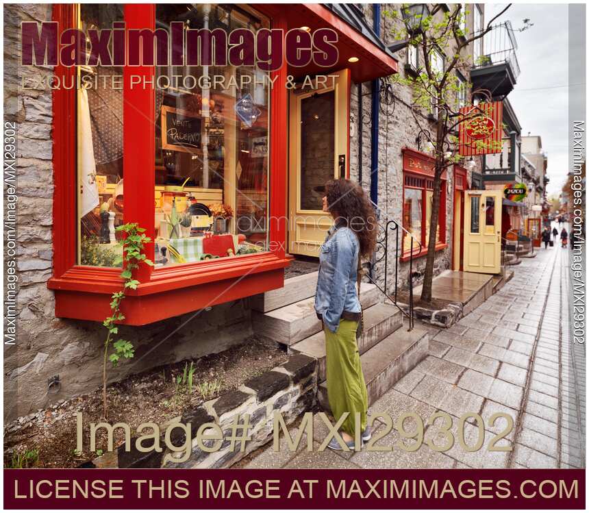 Young woman in front of the shop display on Rue du Petit Champlain historic street in Old Quebec City